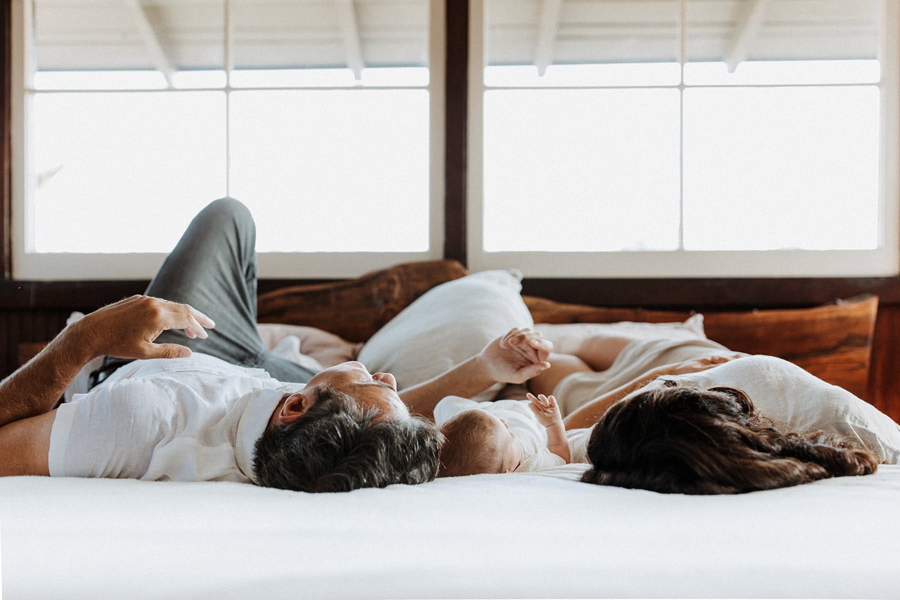 Mother and father and newborn at home in bed