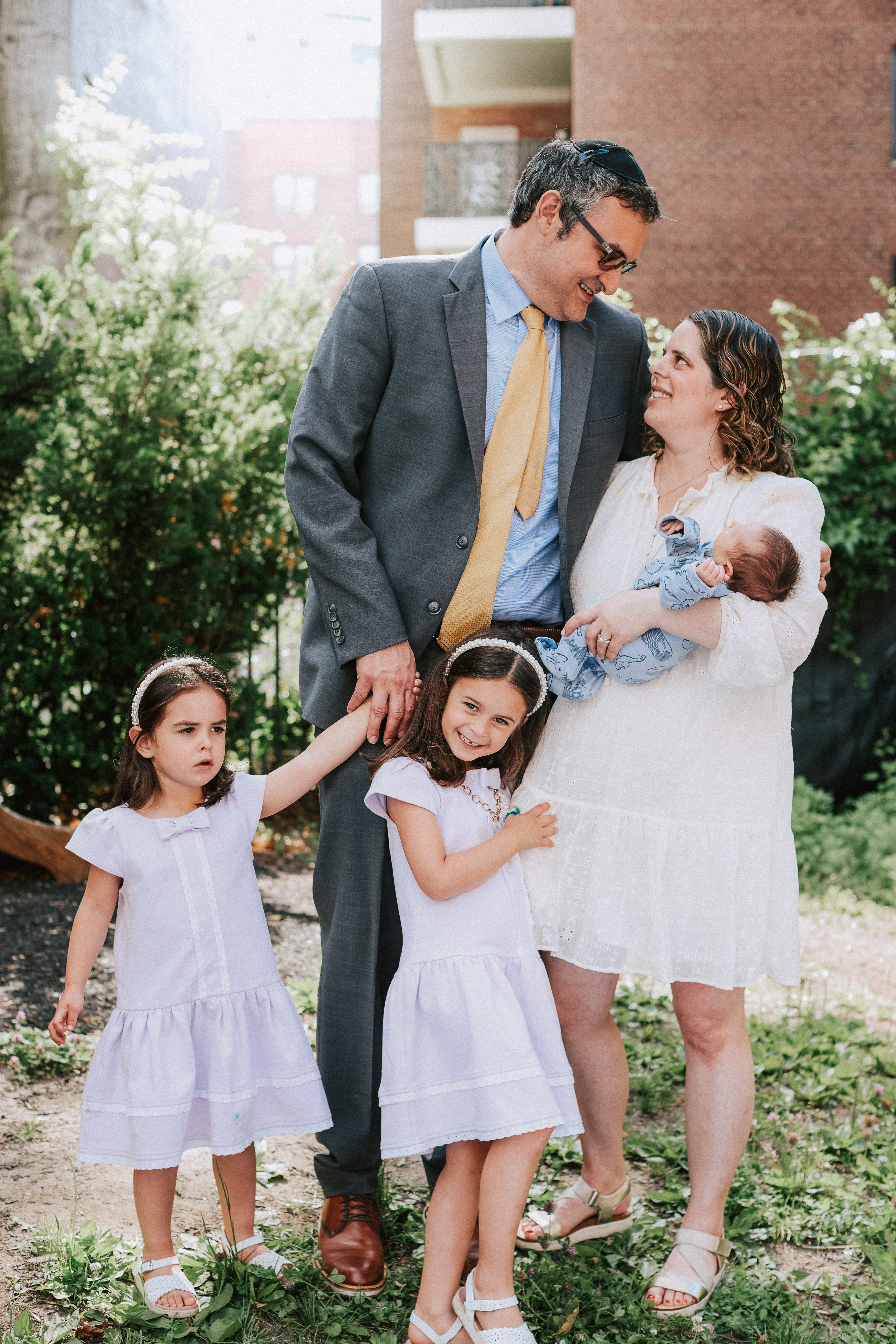 Family portrait of parents, two daughters, and baby boy after his bris