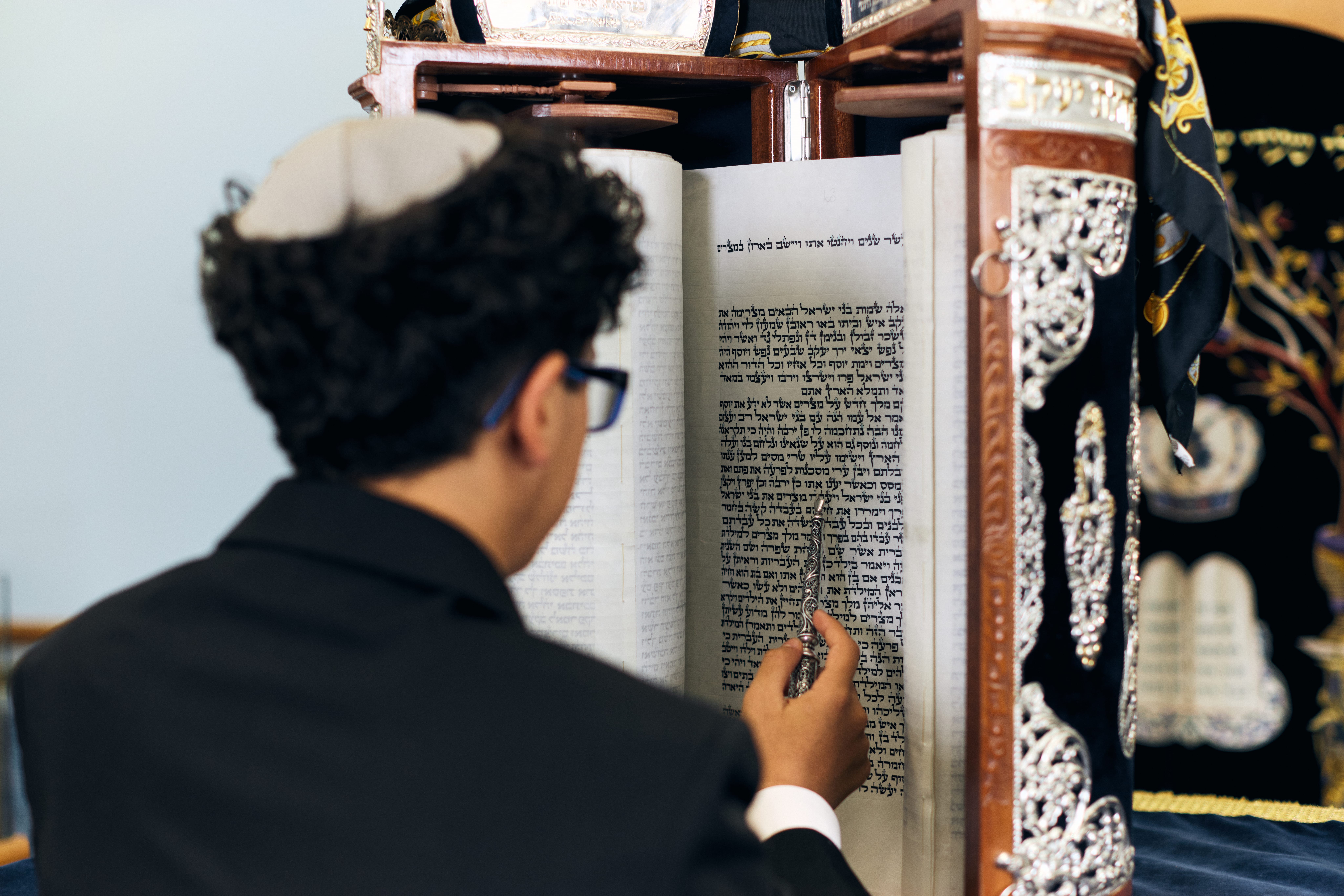 Young man reading a Torah during his Bar Mitzvah portrait session