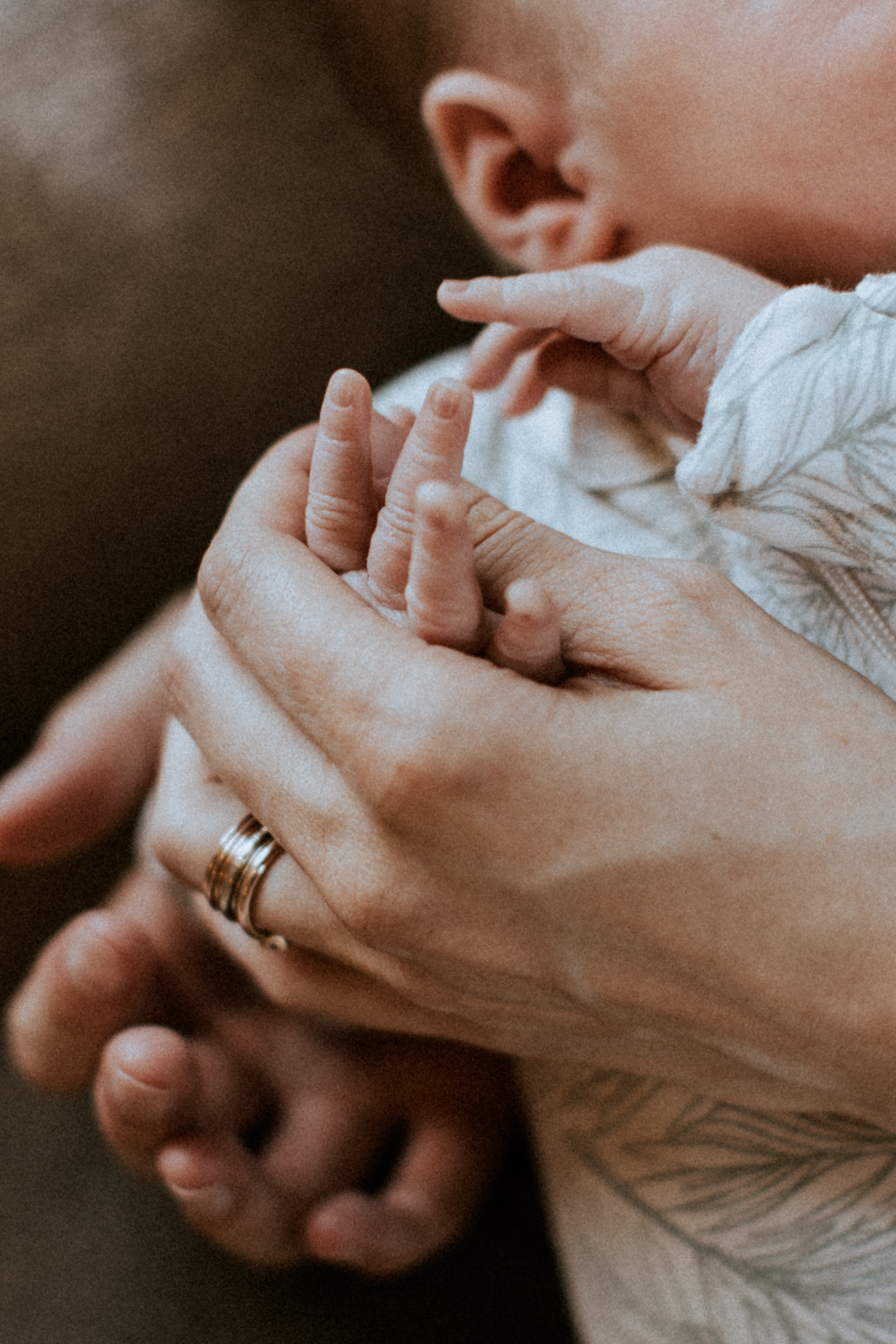 Newborn baby's hands in mom’s.